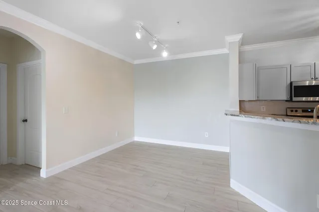 a view of a kitchen with refrigerator and white cabinets