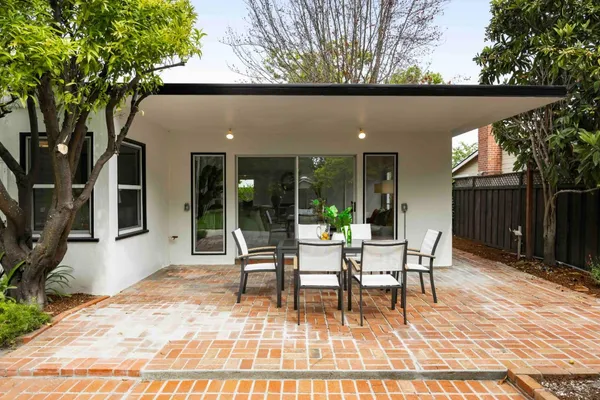 a patio with glass top table and chairs