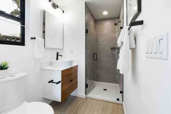 a bathroom with a sink a toilet and shower