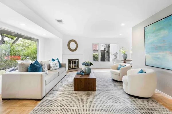a living room with couches a coffee table and a large window with outer view