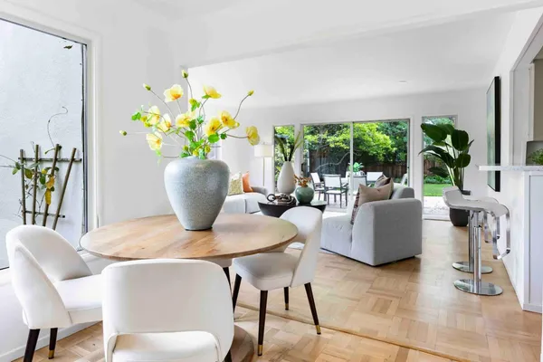 a dining room with furniture potted plants and wooden floor