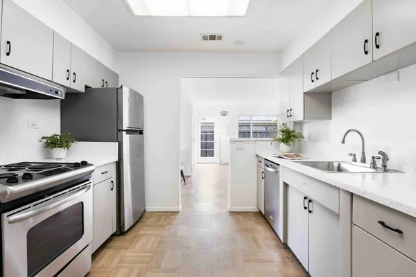 a kitchen with stainless steel appliances a stove sink and refrigerator