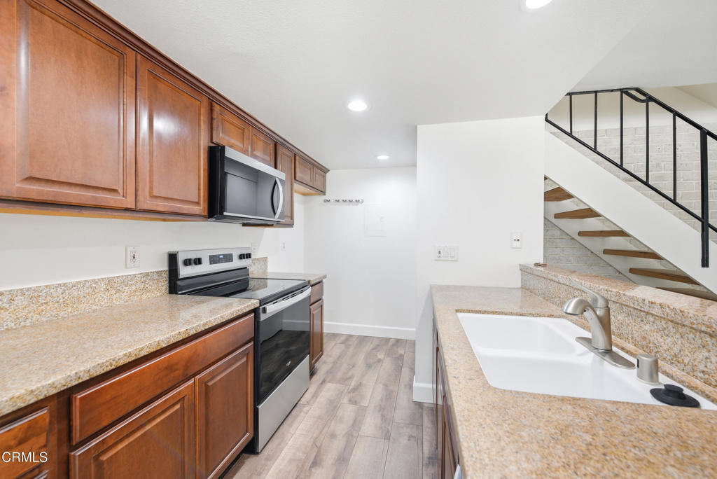 1210 Carlsbad Place Ventura, CA 93003 - Photo 9 of 22 a kitchen with stainless steel appliances granite countertop a sink stove and cabinets