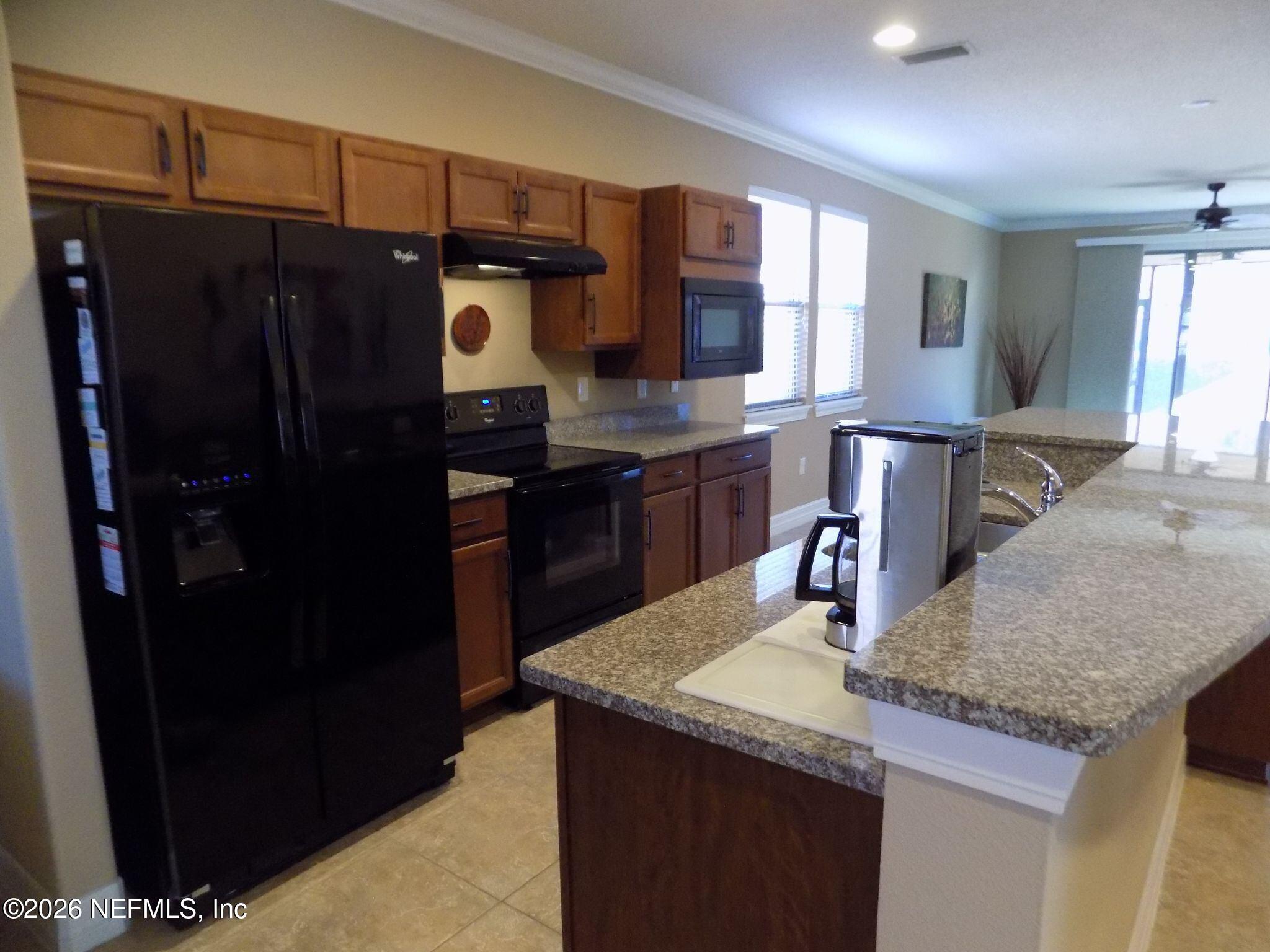 144 Goldenrod Park Road Ponte Vedra, FL 32081 - Photo 13 of 40 a kitchen with a sink a refrigerator and cabinets