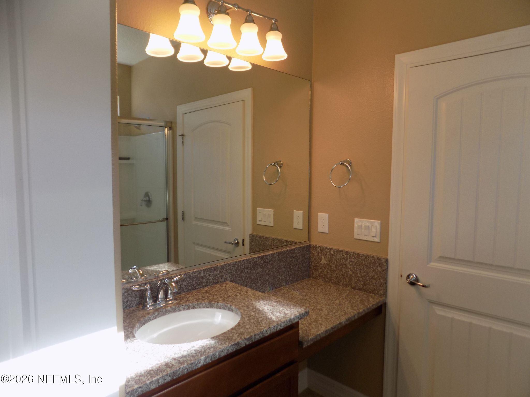 144 Goldenrod Park Road Ponte Vedra, FL 32081 - Photo 22 of 40 a bathroom with a granite countertop sink a mirror and a shower