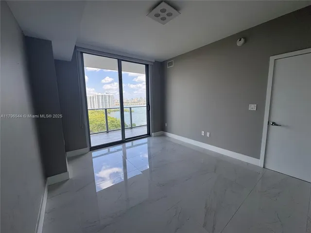a view of an empty room with wooden floor and a table