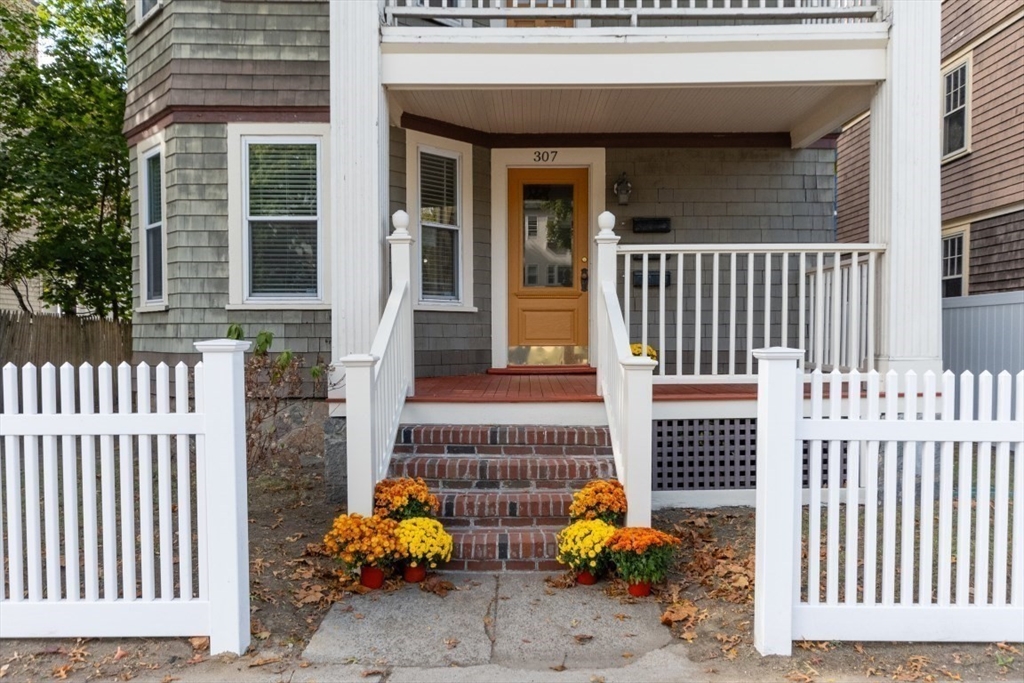 a view of a house with a small yard and wooden fence