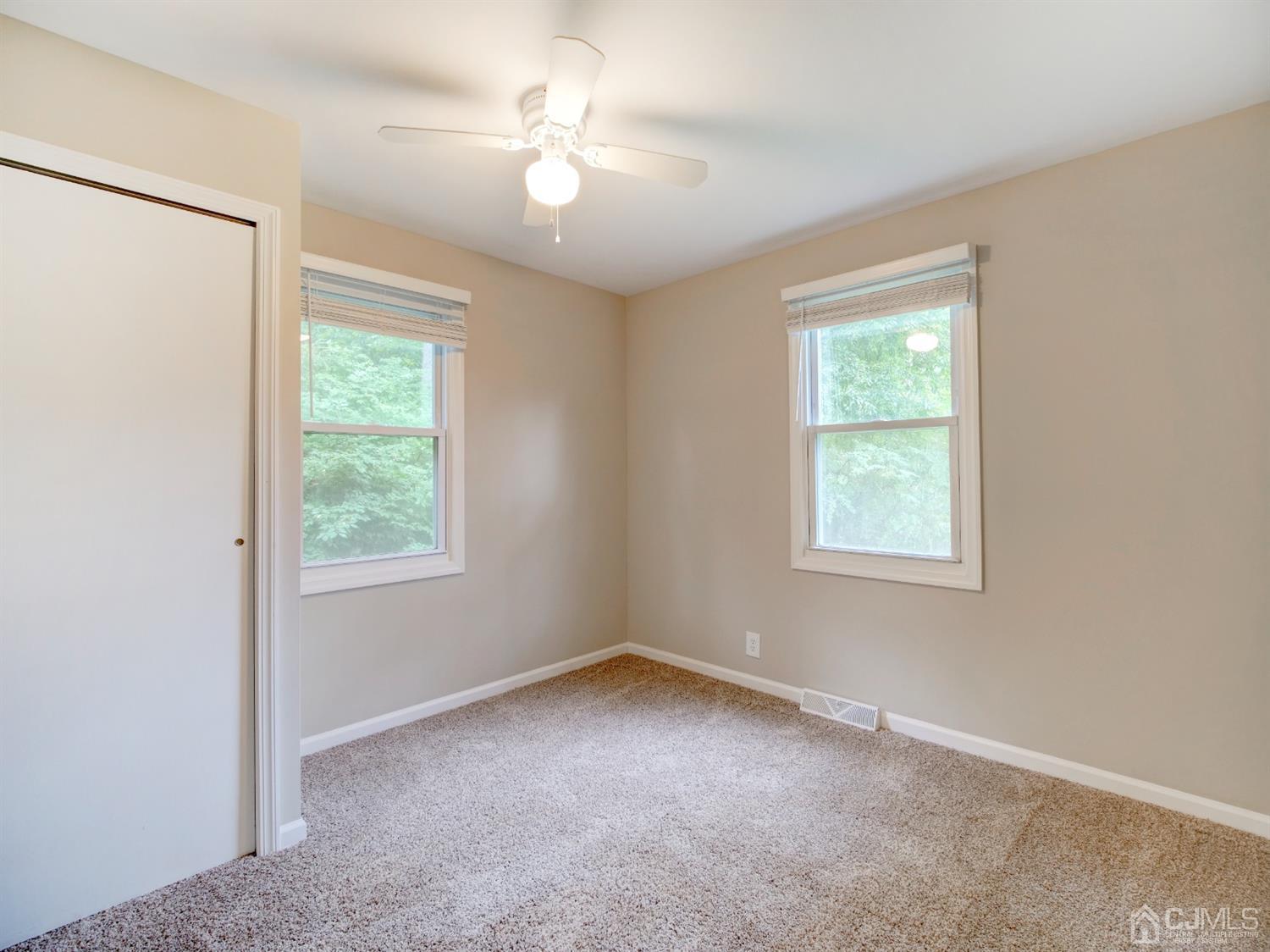 80 Pleasant Valley Road Old Bridge, NJ 08857 - Photo 5 of 15 an empty room with windows and fan