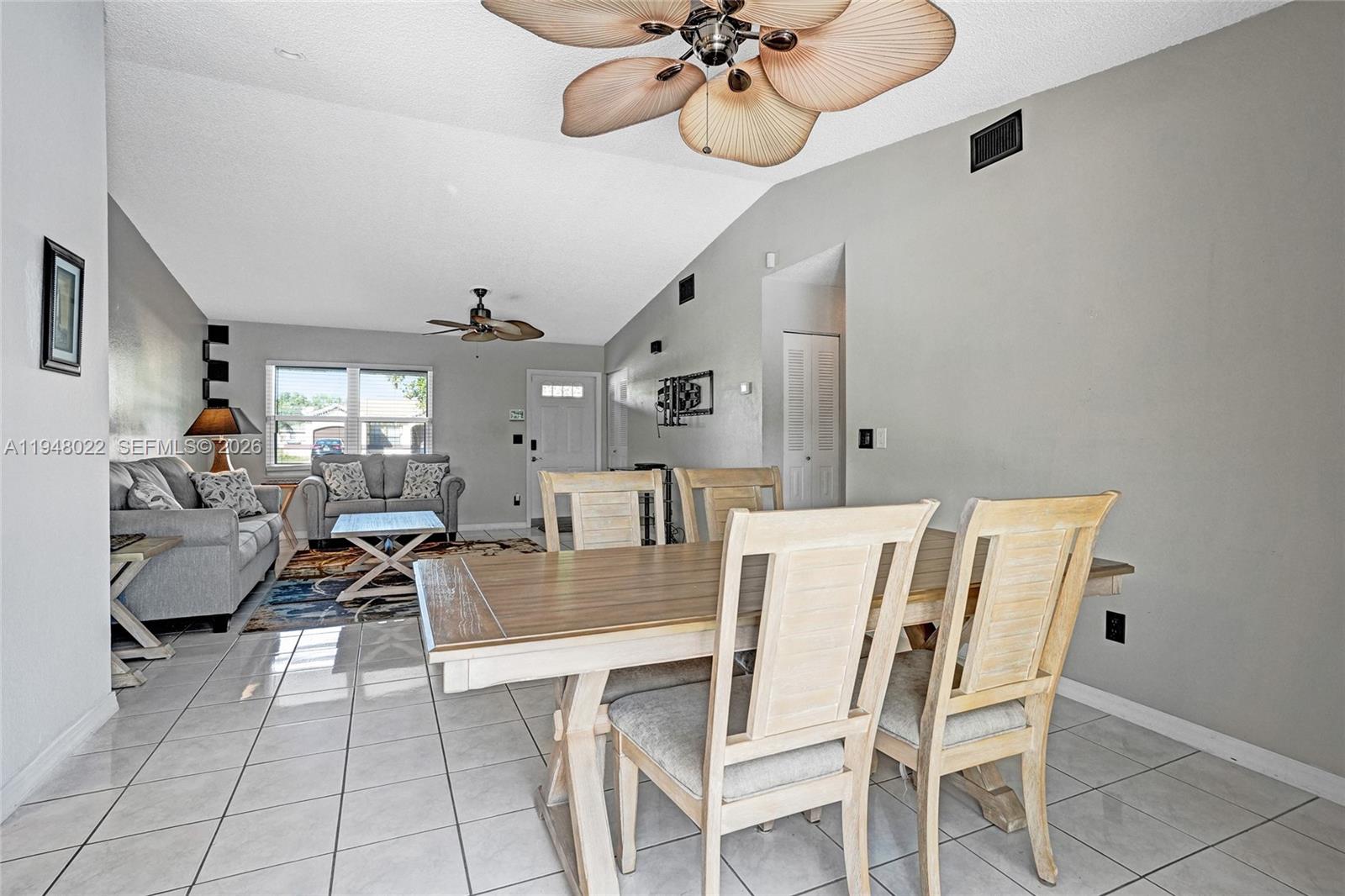 2252 Southeast Rainier Road Port St. Lucie, FL 34952 - Photo 14 of 52 a view of a dining room with furniture and a chandelier fan