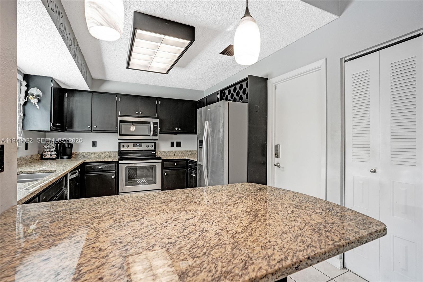 2252 Southeast Rainier Road Port St. Lucie, FL 34952 - Photo 17 of 52 a kitchen with stainless steel appliances granite countertop a refrigerator a stove a sink dishwasher a oven with a dining table and chairs