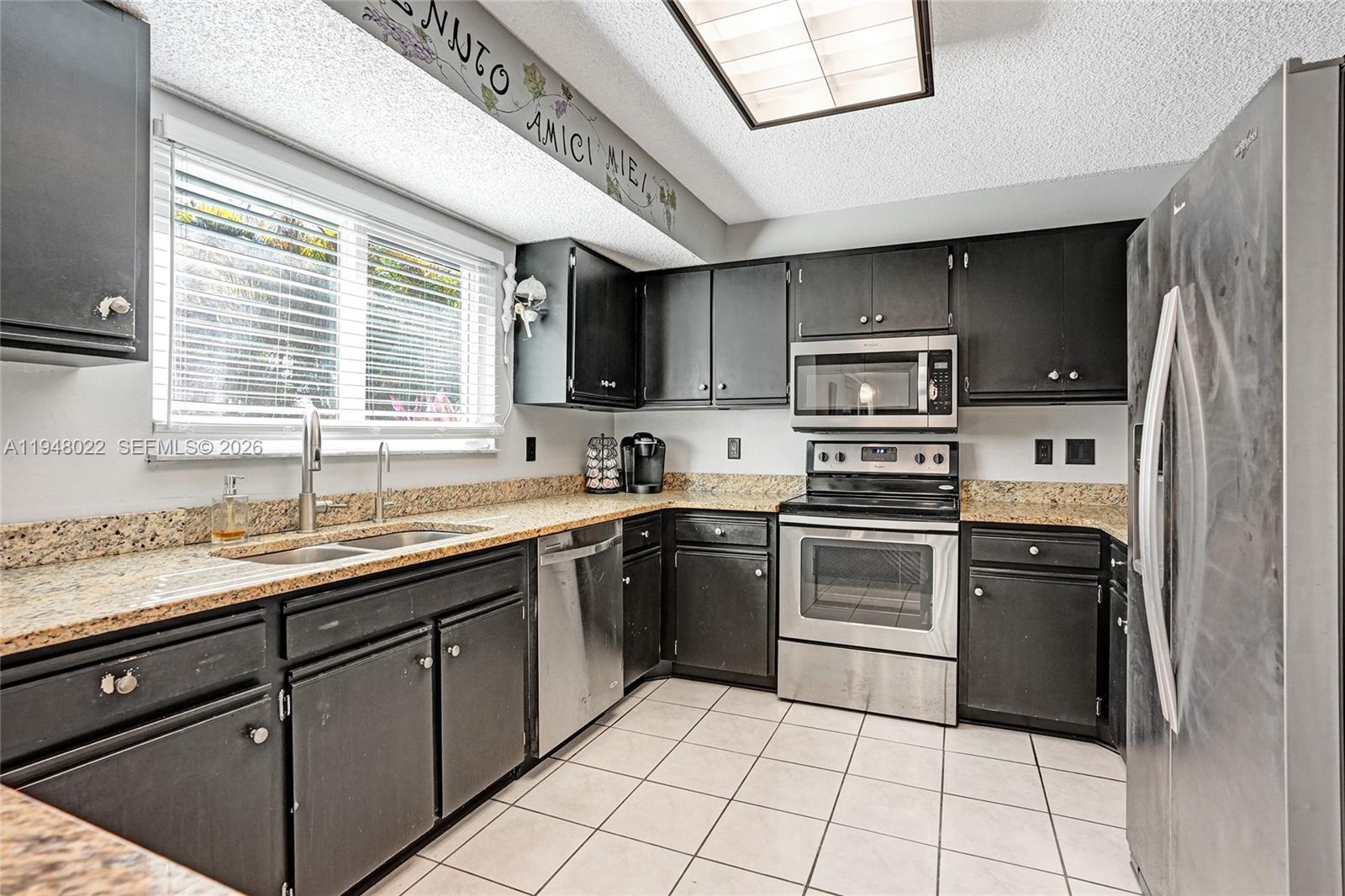 2252 Southeast Rainier Road Port St. Lucie, FL 34952 - Photo 18 of 52 a kitchen with stainless steel appliances granite countertop a sink and a stove