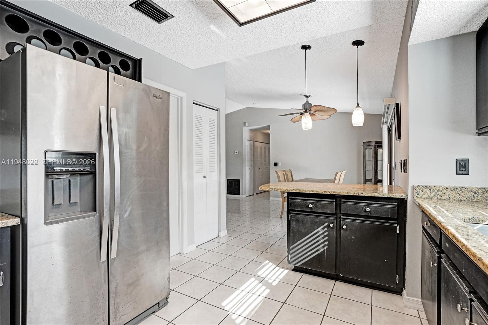 2252 Southeast Rainier Road Port St. Lucie, FL 34952 - Photo 19 of 52 a kitchen with granite countertop a refrigerator and a sink