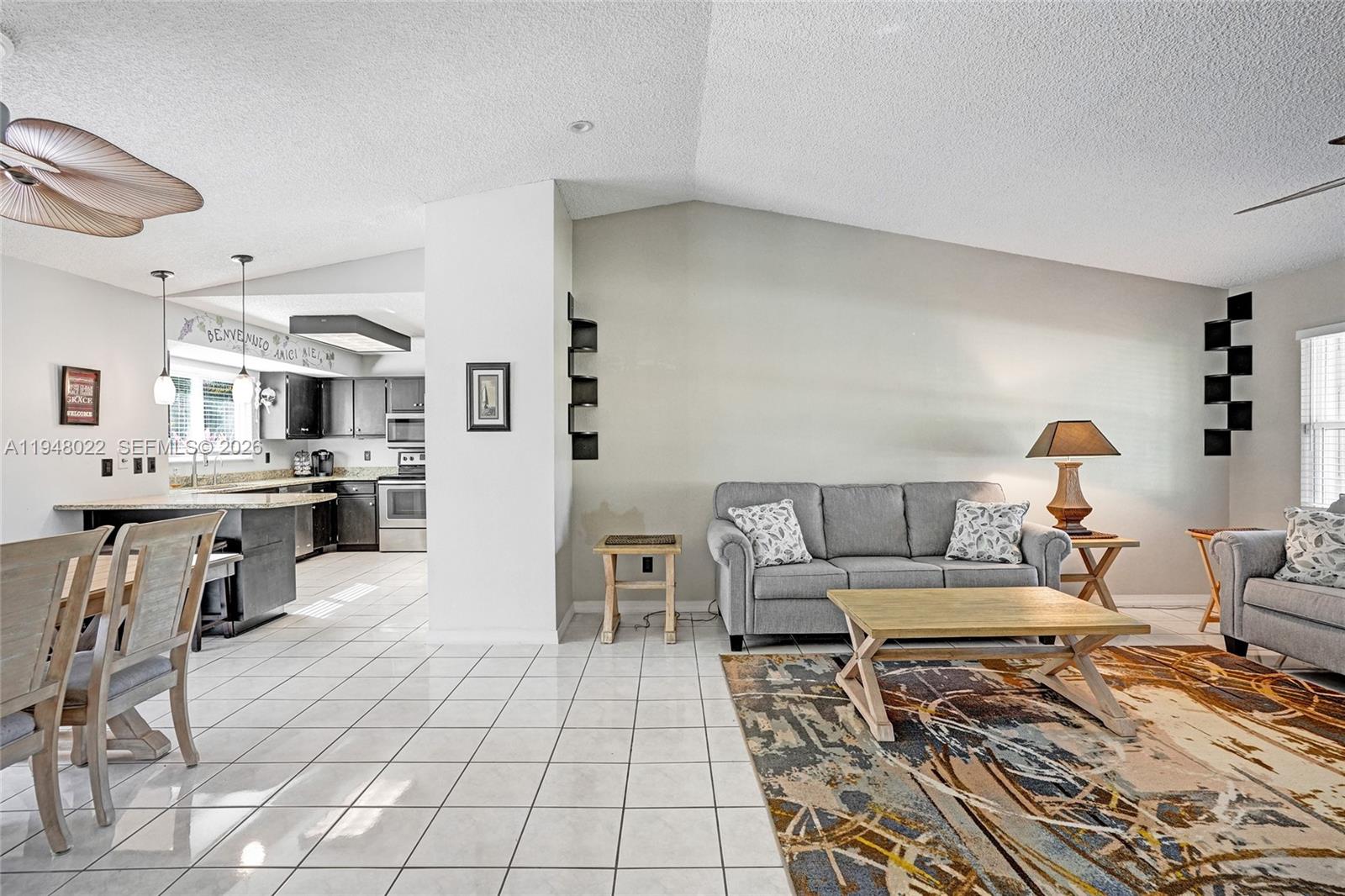 2252 Southeast Rainier Road Port St. Lucie, FL 34952 - Photo 7 of 52 a living room with furniture and a dining table with kitchen view