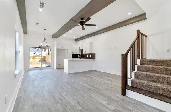 a view of a kitchen with wooden floor and a ceiling fan