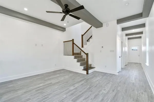 a view of hallway with stairs and wooden floor