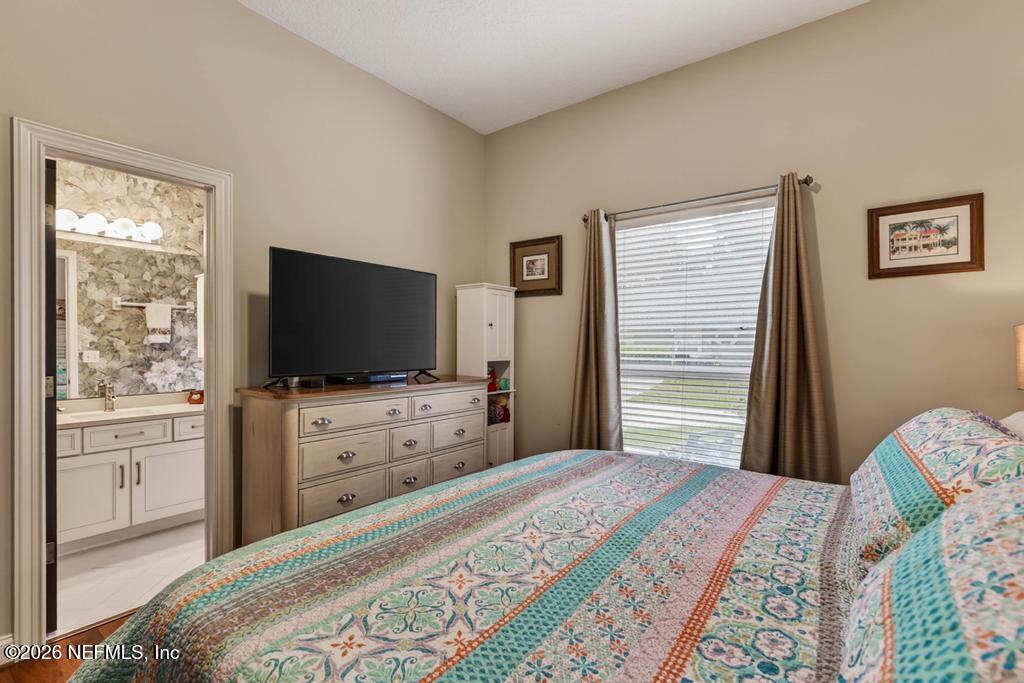 1483 Bridgette Way Fleming Island, FL 32003 - Photo 30 of 63 a bedroom with a bed and a flat screen tv in it
