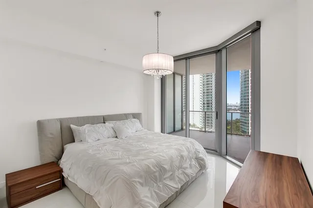 a bedroom with a bed and a chandelier