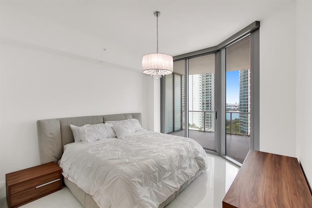 851 Northeast 1st Avenue, Unit 2005 Miami, FL 33132 - Photo 12 of 23 a bedroom with a bed and a chandelier