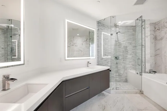 a bathroom with a tub sink shower and mirror
