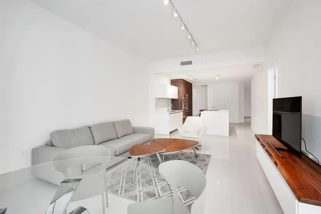 a living room with furniture a flat screen tv and a fireplace