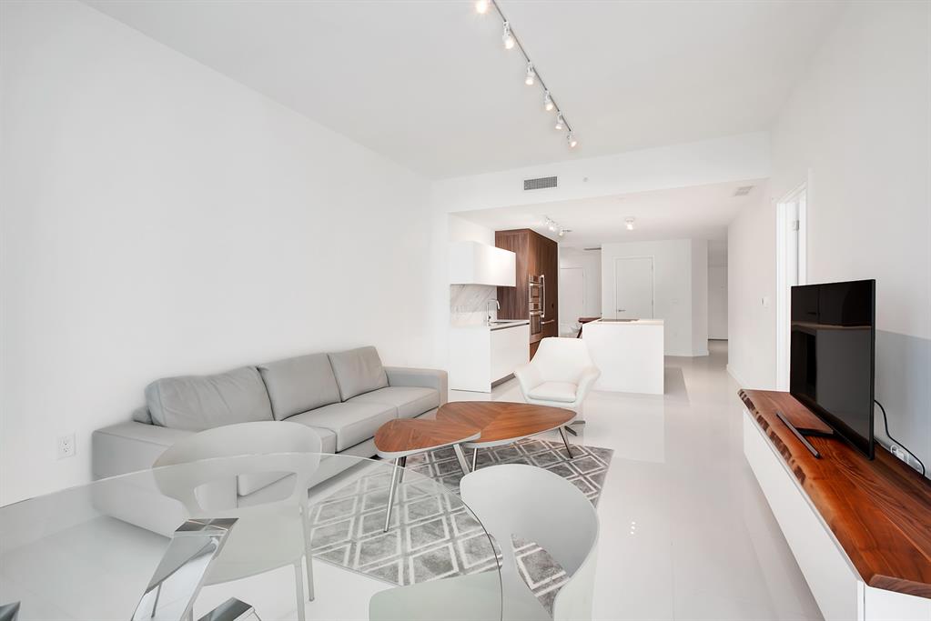 851 Northeast 1st Avenue, Unit 2005 Miami, FL 33132 - Photo 4 of 23 a living room with furniture a flat screen tv and a fireplace