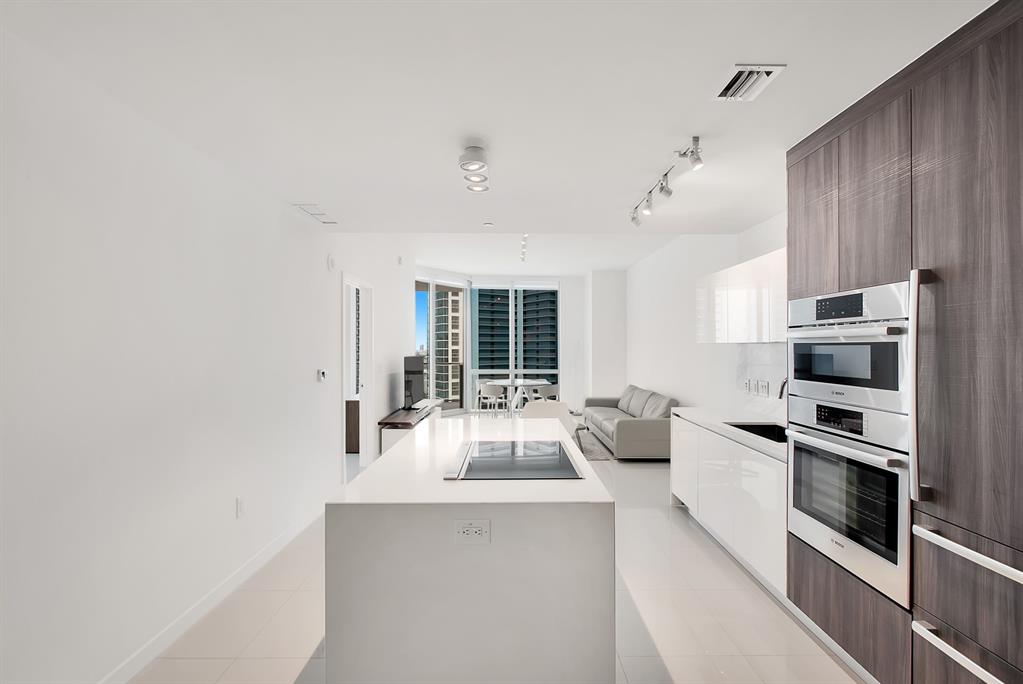 851 Northeast 1st Avenue, Unit 2005 Miami, FL 33132 - Photo 7 of 23 a kitchen with stainless steel appliances a stove and more cabinets