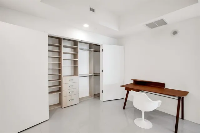a view of walk in closet with empty racks