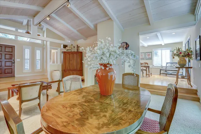 a dining room with furniture and a floor to ceiling window