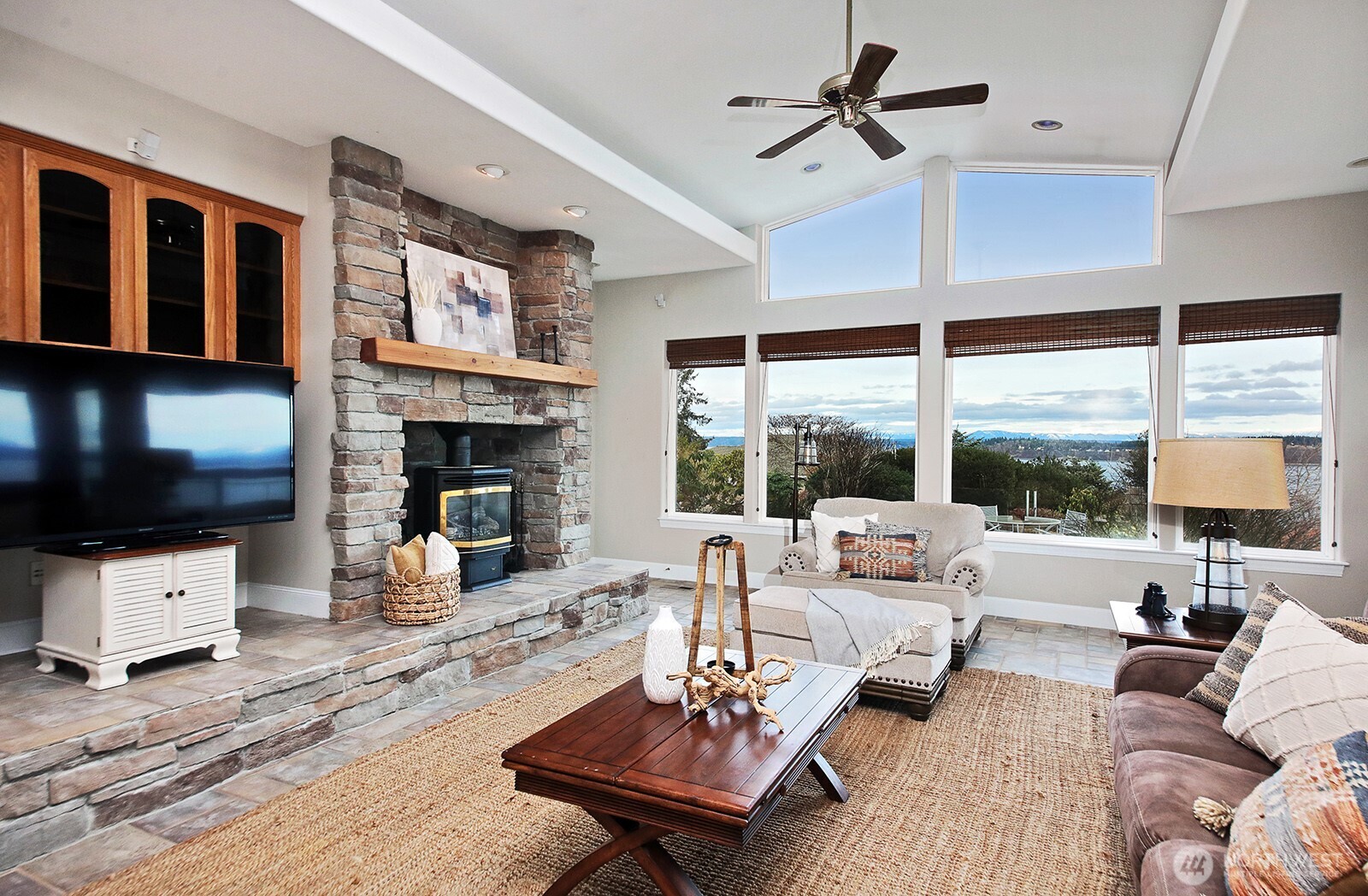 4694 Wrightsman Place Clinton, WA 98236 - Photo 3 of 38 a living room with furniture a fireplace and a flat screen tv