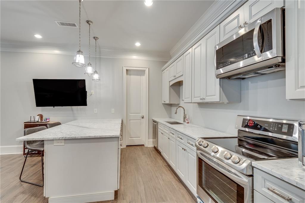 187 Fontaine Road Southwest Mableton, GA 30126 - Photo 59 of 84 a kitchen with stainless steel appliances a stove microwave and sink