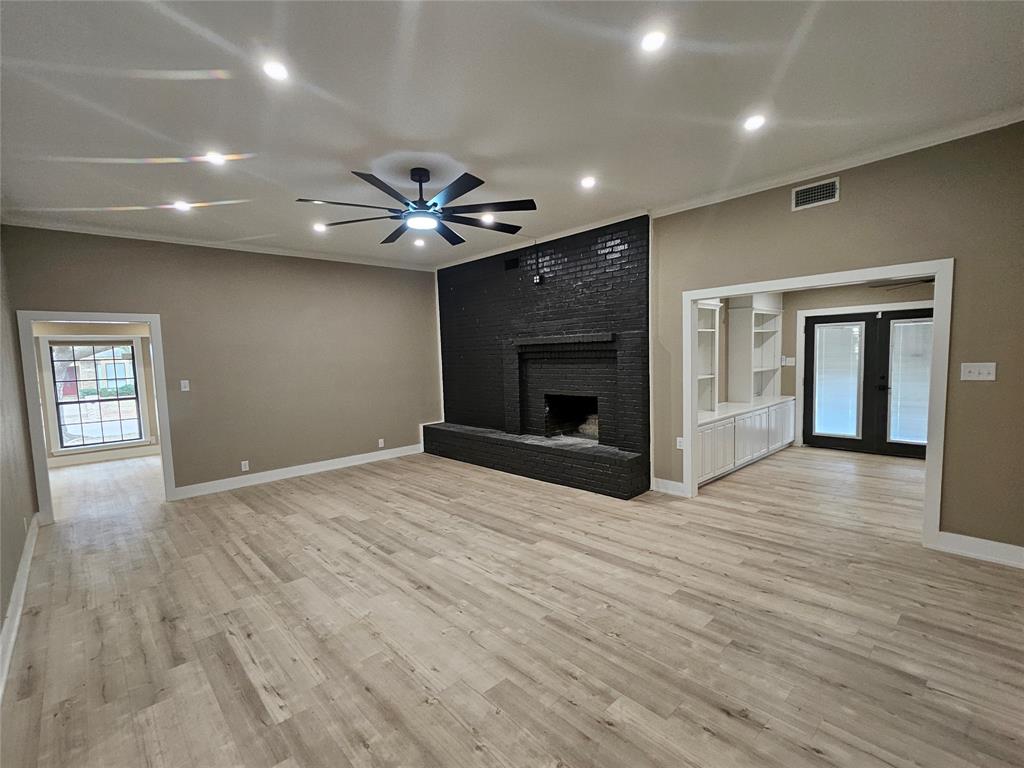 5501 Chimney Rock Road Abilene, TX 79606 - Photo 4 of 14 an empty room with wooden floor a fireplace and a window