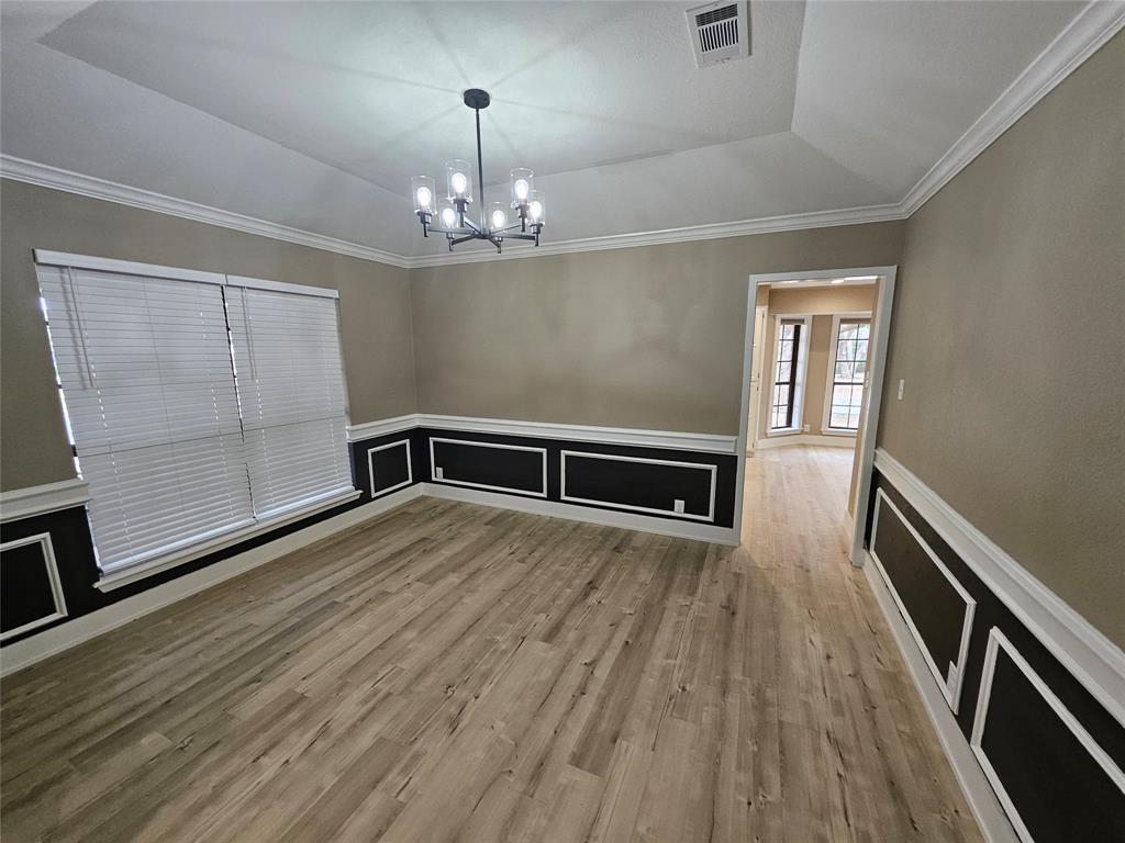 5501 Chimney Rock Road Abilene, TX 79606 - Photo 5 of 14 a view of an empty room with wooden floor and a window