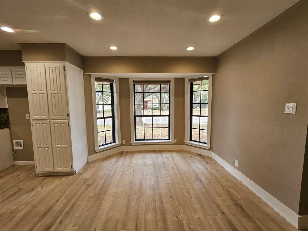 5501 Chimney Rock Road Abilene, TX 79606 - Photo 6 of 14 a view of an empty room with wooden floor and a window