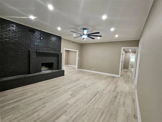 an empty room with wooden floor and a fireplace