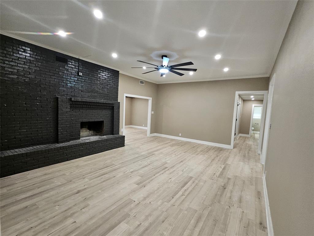 5501 Chimney Rock Road Abilene, TX 79606 - Photo 8 of 14 an empty room with wooden floor and a fireplace