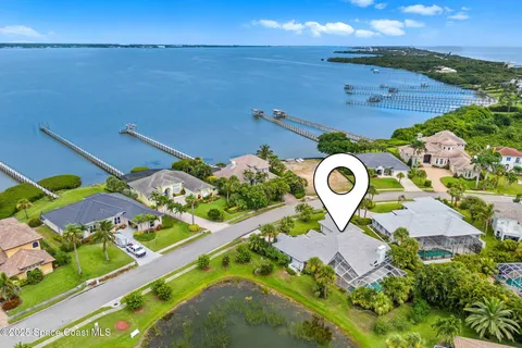 an aerial view of a house with a yard and lake view