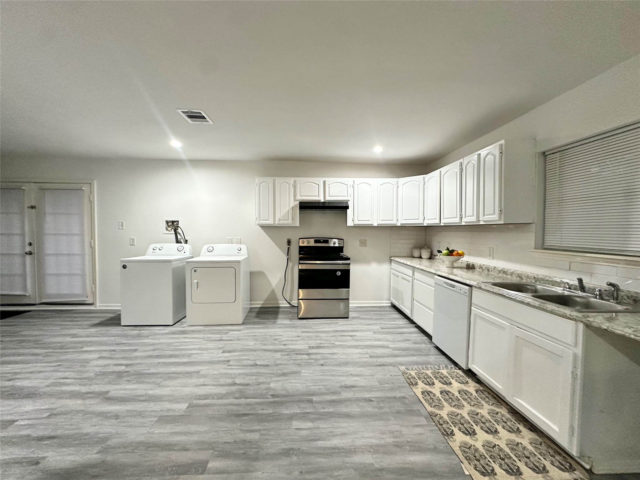 5346 Windswept Lane Houston, TX 77056 - Photo 12 of 20 a large white kitchen with stainless steel appliances granite countertop a stove and a sink