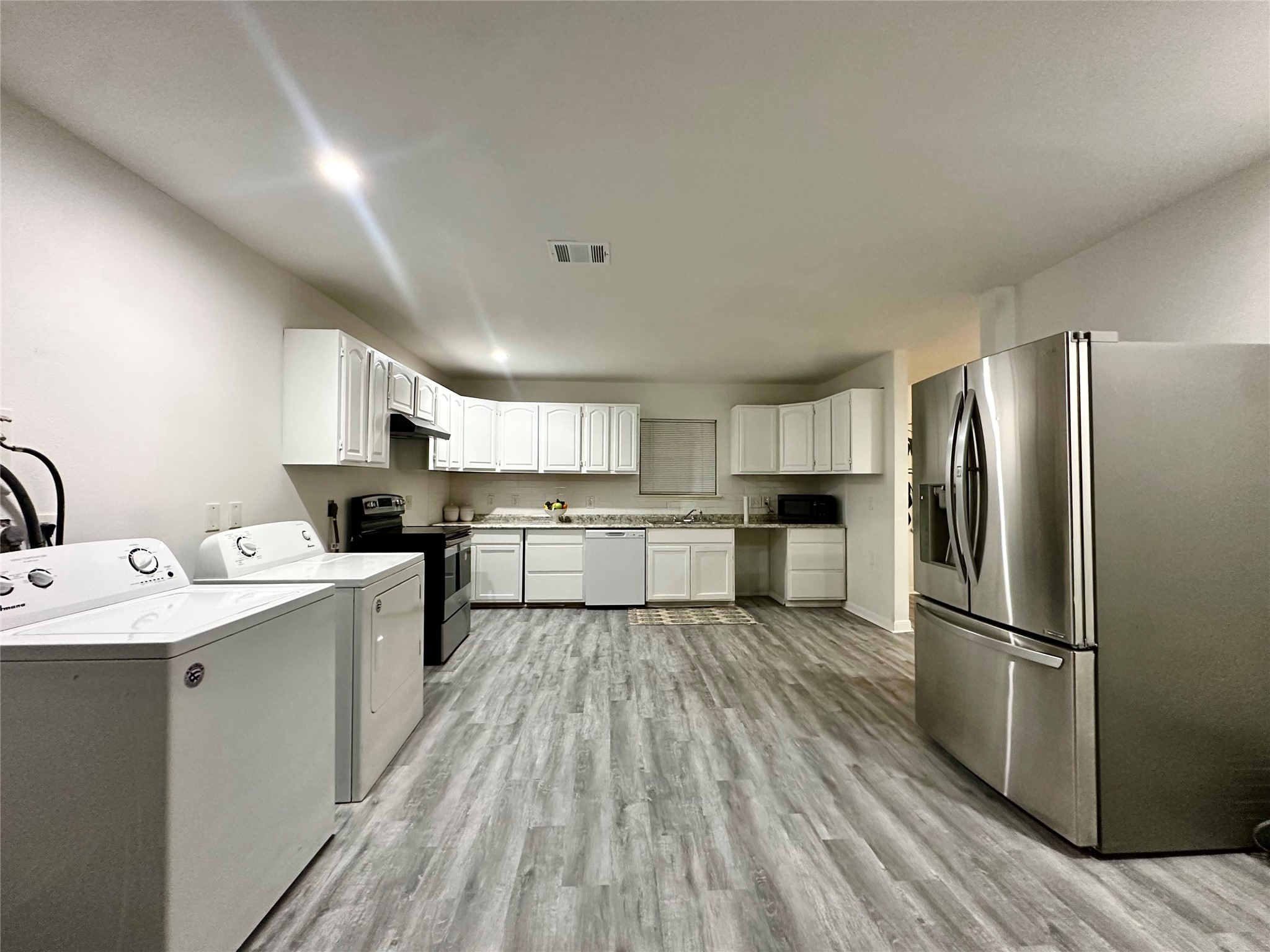5346 Windswept Lane Houston, TX 77056 - Photo 10 of 20 a kitchen with a refrigerator a sink dishwasher and a stove with wooden floor
