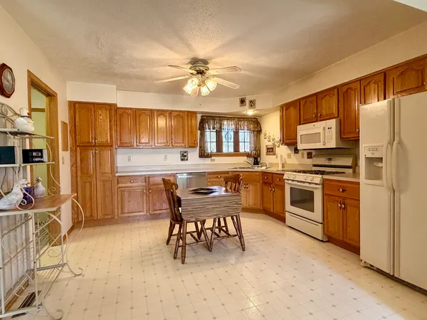 a kitchen with a chandelier stainless steel appliances and dining table