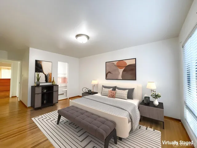 a bedroom with a bed and wooden floor