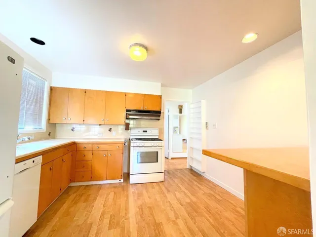 a view of a kitchen with a sink and wooden floor