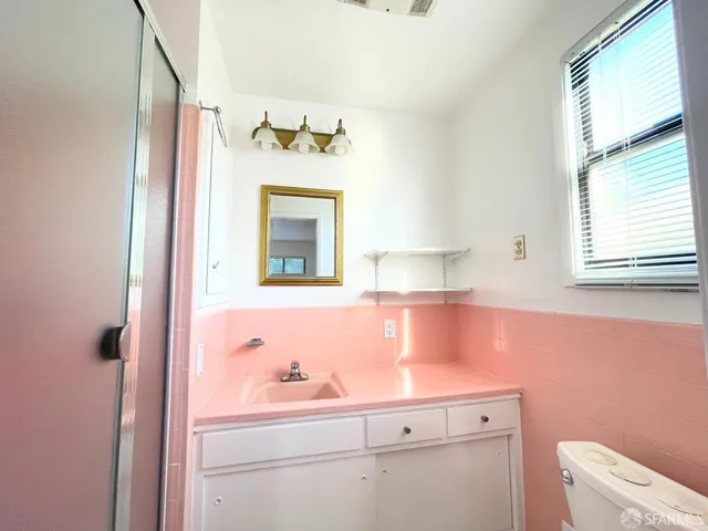 a bathroom with a sink a toilet and mirror