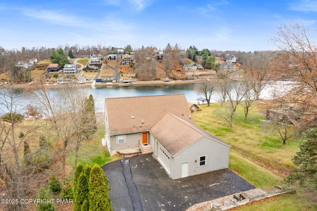an aerial view of a house with a yard and lake view