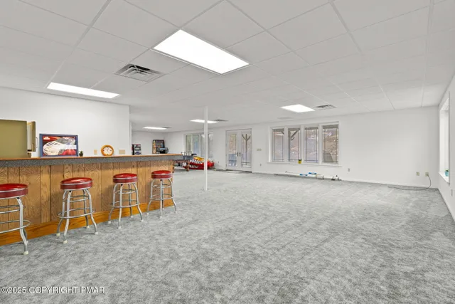 a view of a house with a big yard and large trees