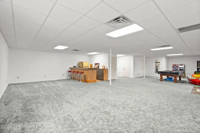 an aerial view of a house with a garden and a building in the background