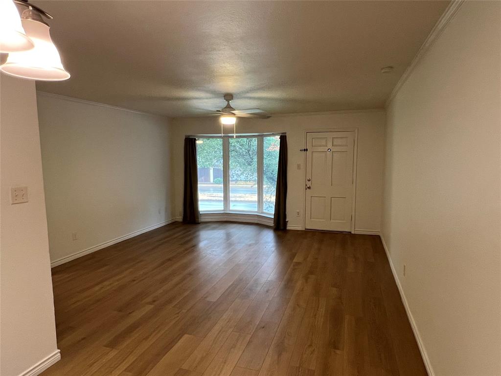 3929 Inwood Road, Unit 2021 Dallas, TX 75209 - Photo 8 of 24 Spacious living area featuring wood-finish flooring, a bay window, and a ceiling fan