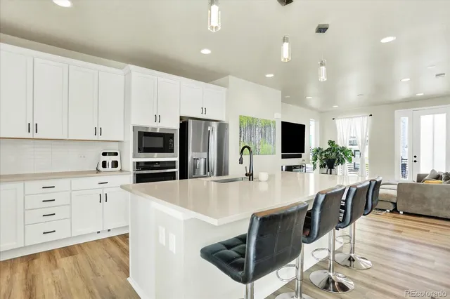 a large kitchen with stainless steel appliances a large counter top space appliances and cabinets