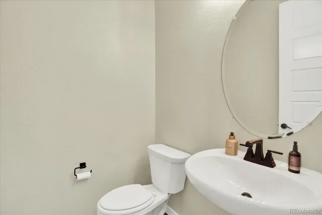 a bathroom with a sink mirror and toilet