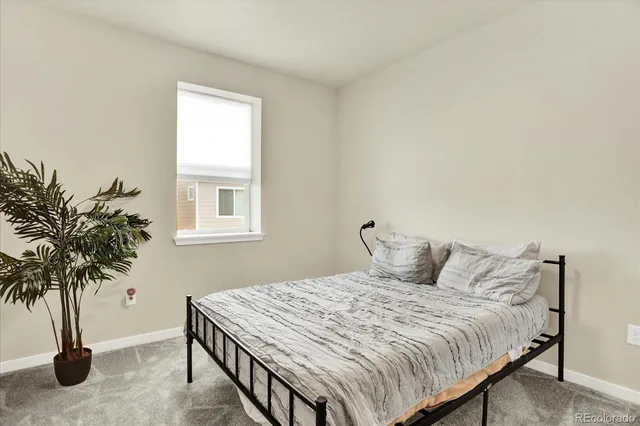 a bedroom with a bed and a potted plant