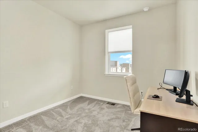 a view of a workspace with furniture and a window